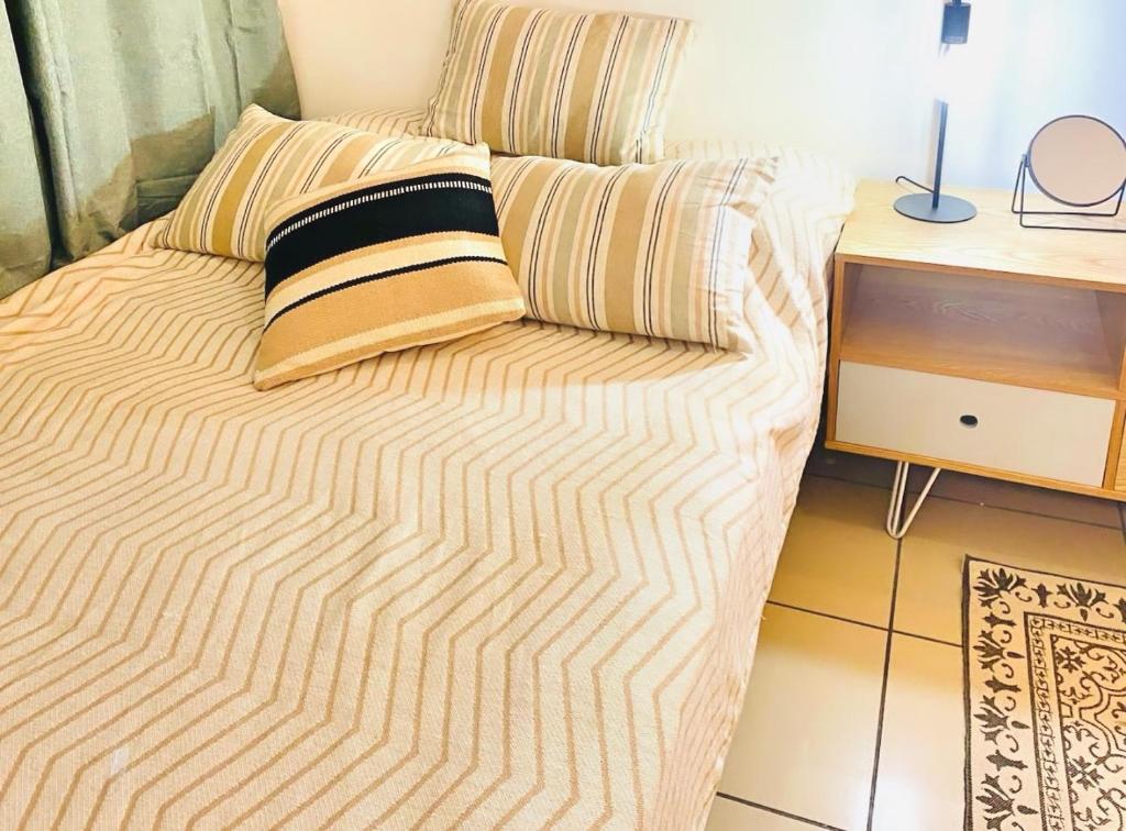 - un lit avec une couverture rayée et une table dans l'établissement KEY BISCAYNE - Boucan Canot plage, à Saint-Gilles les Bains