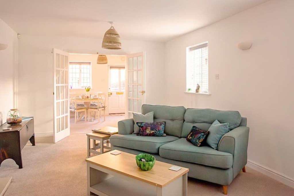 a living room with a blue couch and a table at Chaveney Cottage in Quorndon