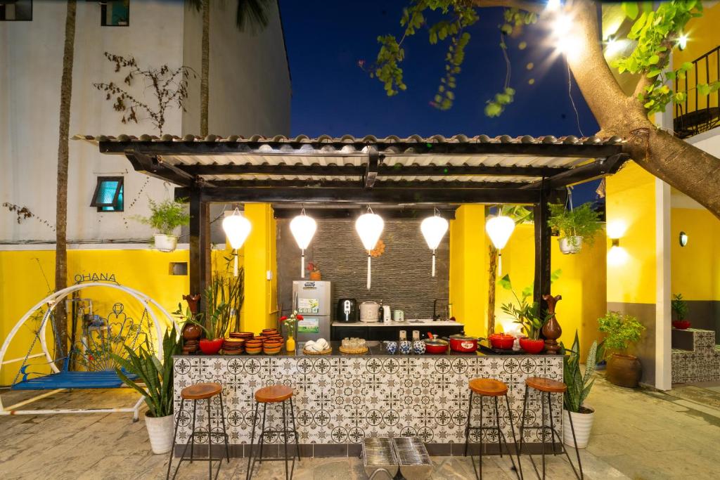 a bar with stools in front of a counter at Oha Hoi An Villa in Hoi An