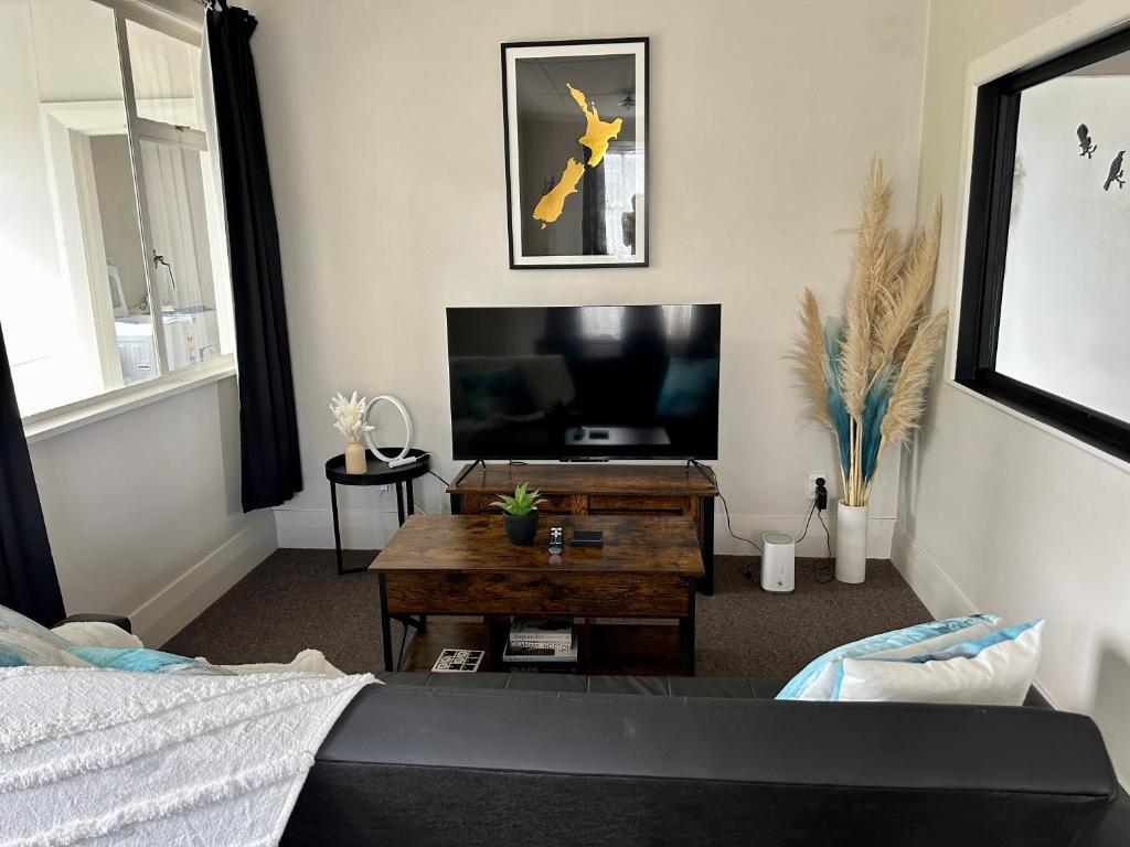 a living room with a television and a coffee table at Oamaru Villa in Oamaru