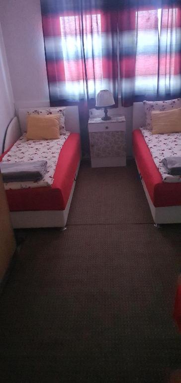 a room with two beds and a table with a lamp at MIMA in Jajce