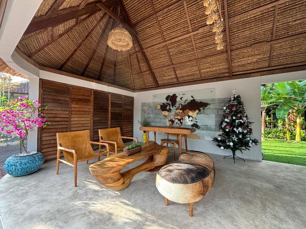 a living room with a table and chairs and a christmas tree at Bali Cozy Bungalows, Nusa Dua Benoa in Nusa Dua