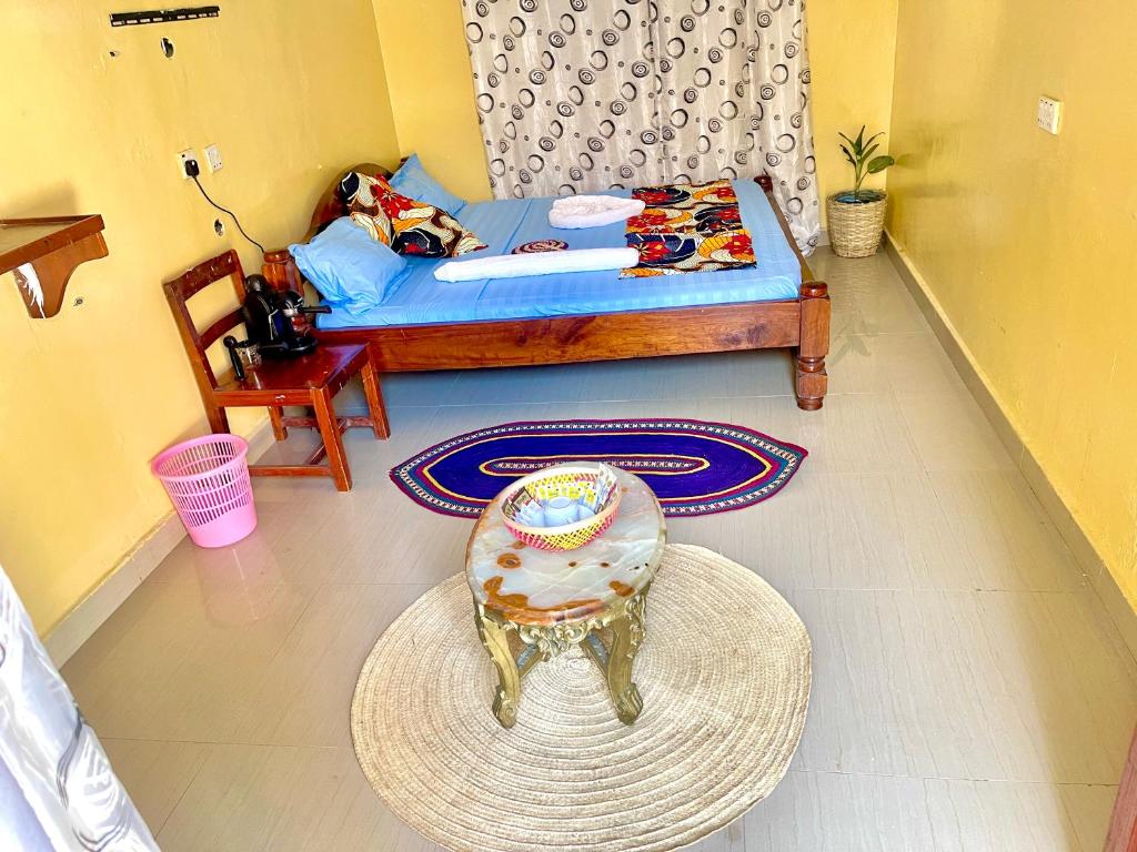 a bedroom with a bed and a table and a stool at Mystic Manor Stonetown B&B in Stone Town