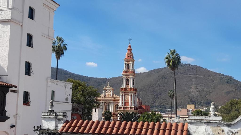een gebouw met een klokkentoren voor een berg bij Departamento temporario en Salta la Linda in Salta