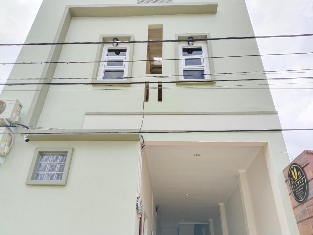 un edificio blanco con ventanas y cables en U Eleven Syariah Homestay, en Tangerang