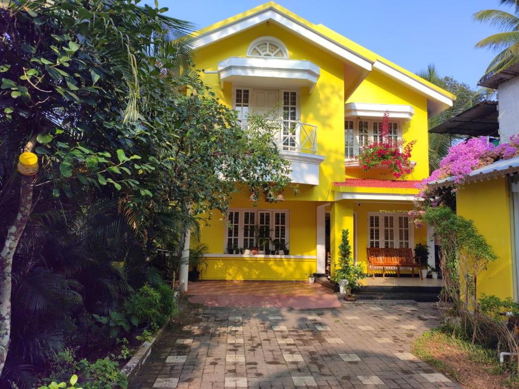 uma casa amarela com uma entrada em frente em Vivaresidence Homestay em Alappuzha