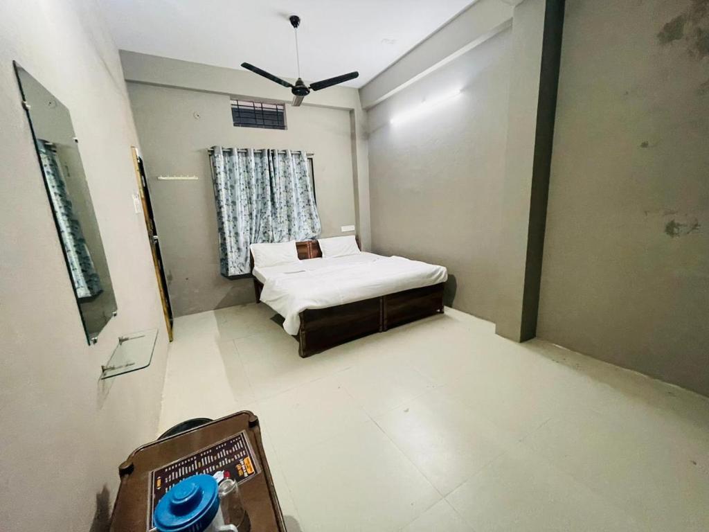 a small bedroom with a bed and a ceiling fan at Hotel Swastik Palace in Maheshwar