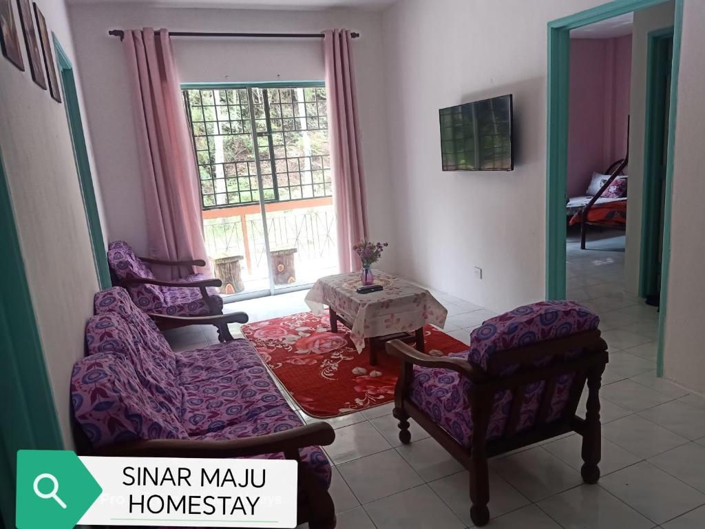 a living room with two chairs and a table at Sinar Maju Homestay in Tanah Rata