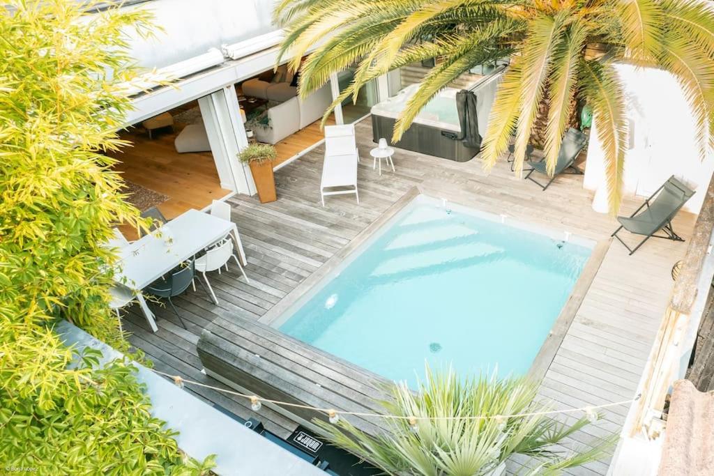 una vista aérea de una piscina con mesa y sillas en Superbe maison d'architecte entièrement climatisée avec piscine et spa professionnel, en Talence