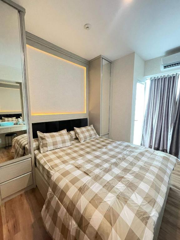 - une chambre avec un lit et une grande fenêtre dans l'établissement Grand Kamala Lagoon By Beatrix Property, à Pekayon Satu