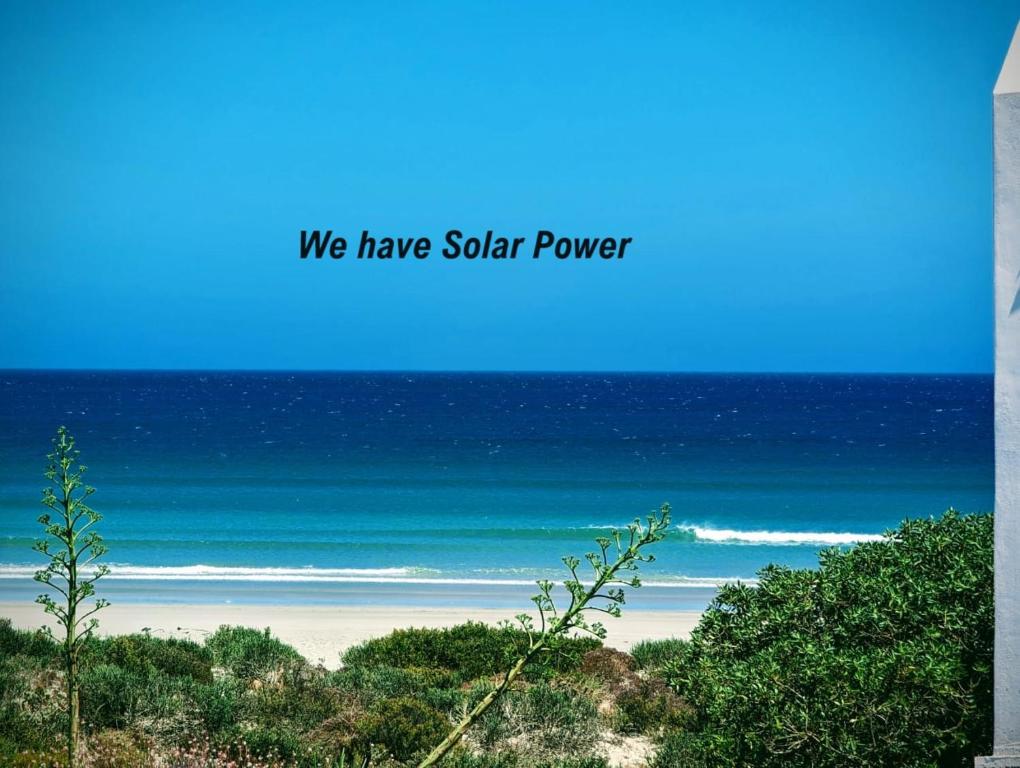 a picture of a beach with the words we have solar power at Nova Vida in Paternoster