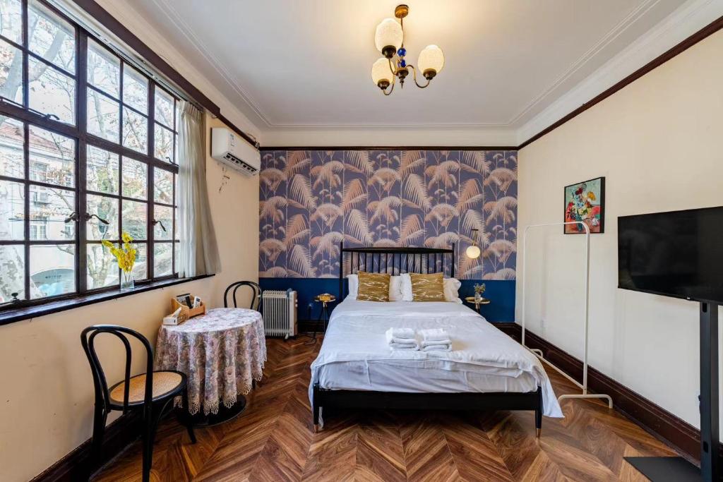 een slaapkamer met een bed en een televisie bij Shanghai Century Old House Downtown B&B in Shanghai