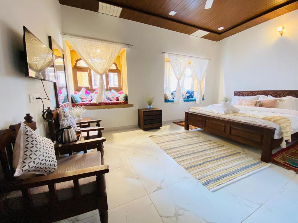 - une chambre avec un grand lit et quelques fenêtres dans l'établissement Jasmer Haveli, à Jaisalmer