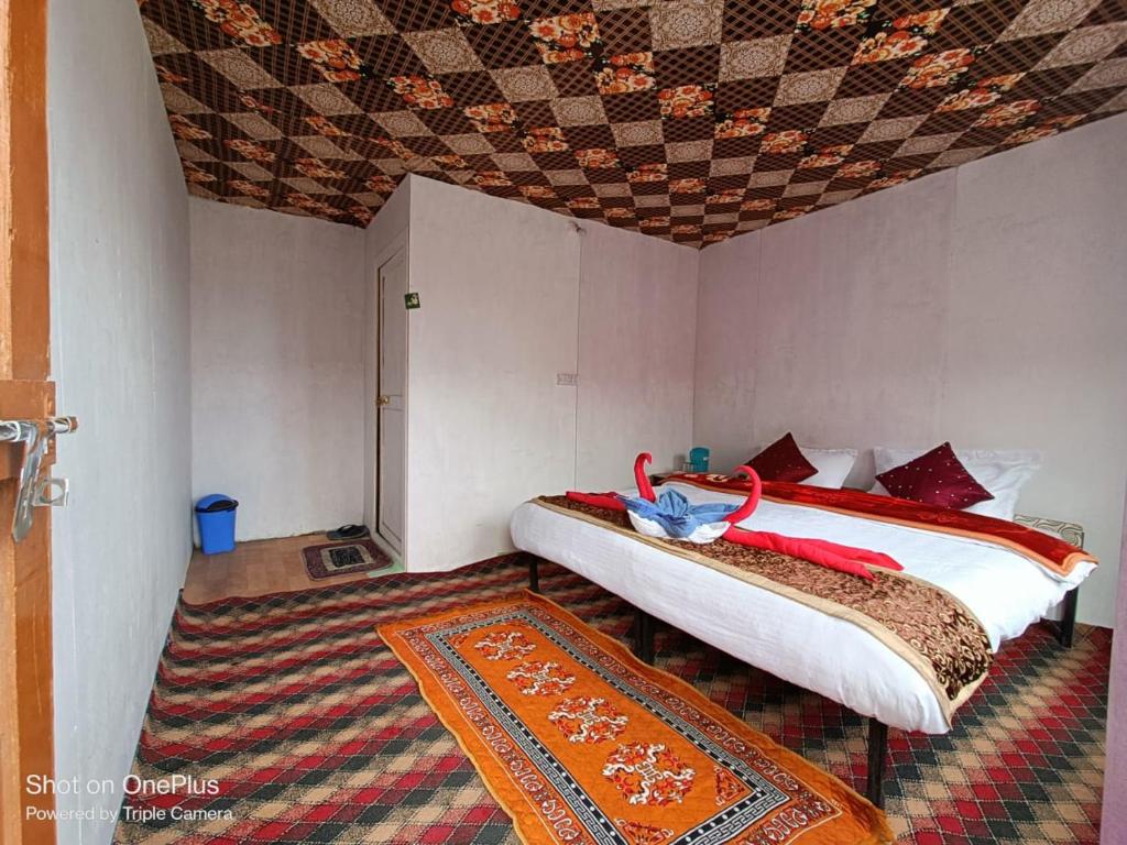 LukungにあるBlue Chill Cottage Pangongのベッドルーム1室(ベッド2台、ラグ付)