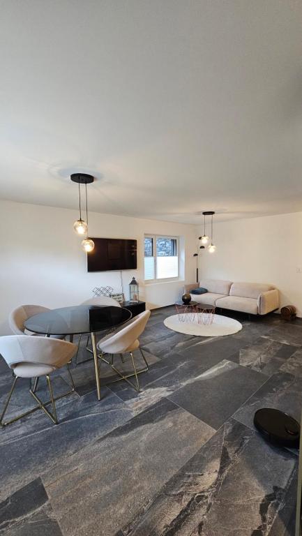 sala de estar con sofá, mesa y sillas en GP Luxury Apartment, en Schönenwerd