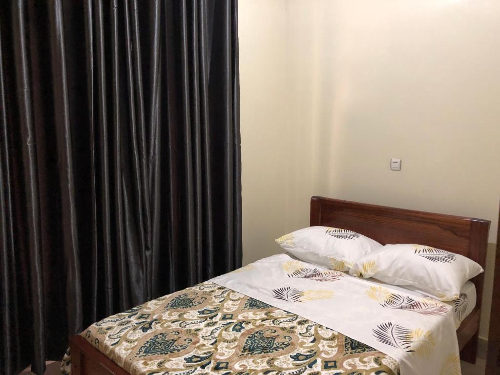 ein Schlafzimmer mit einem Bett mit einem schwarzen Vorhang in der Unterkunft Luxury Furnished and Serviced Home in Kigali