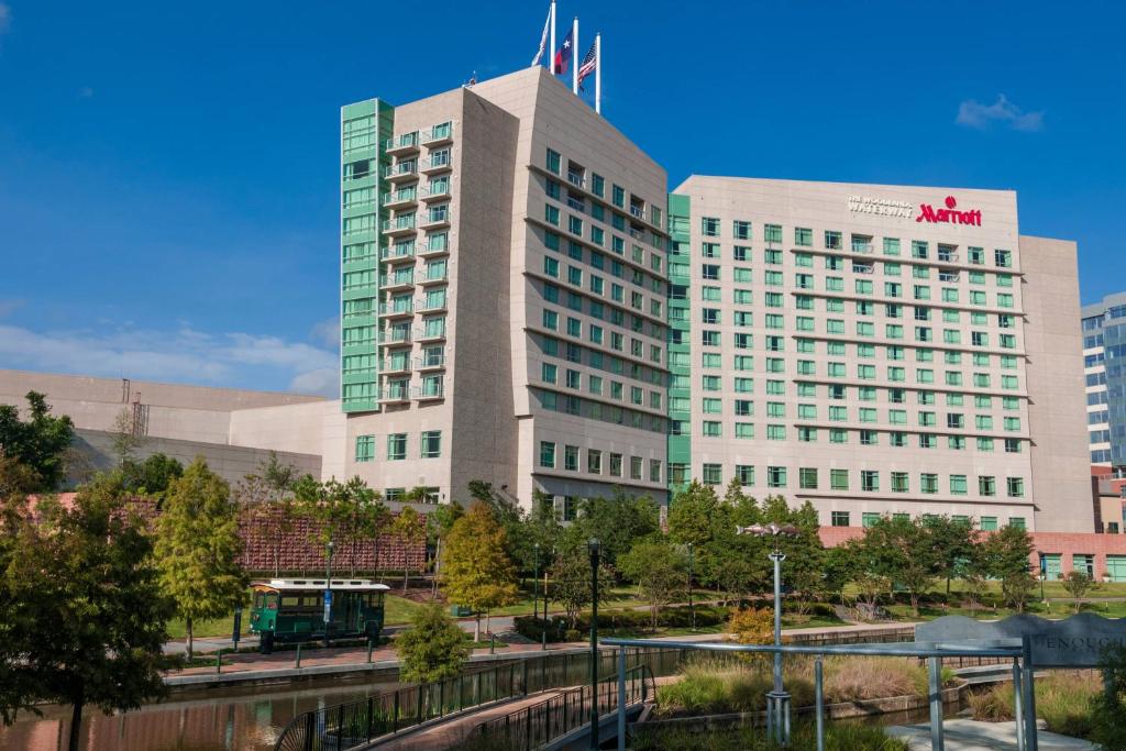 un gran edificio con un tren delante en The Woodlands Waterway Marriott Hotel and Convention Center en The Woodlands