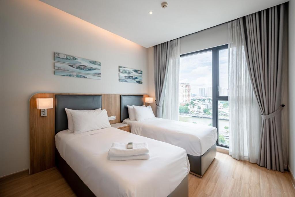 um quarto de hotel com duas camas e uma grande janela em D1 Mension Luxury Apartment- Chloe Dang em Ho Chi Minh