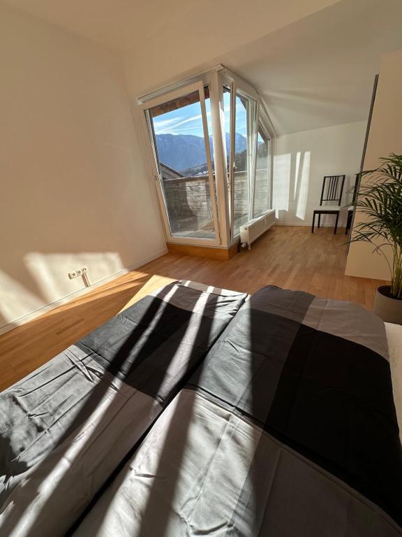 a bedroom with a bed and a large window at Geräumiges sonniges Apartment mit Bergblick in Imst