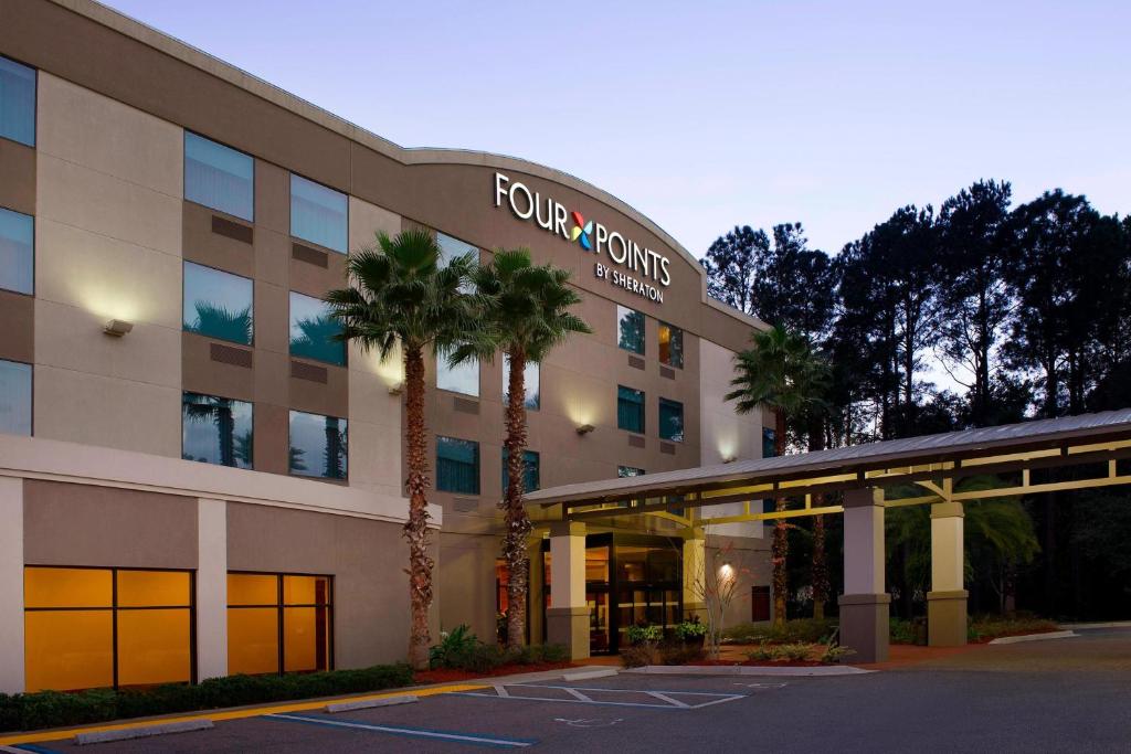a front view of a hotel with palm trees at Four Points by Sheraton Jacksonville Baymeadows in Jacksonville
