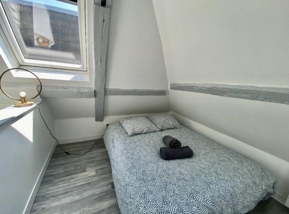 a small room with a bed and a window at PETIT CROIX in Rouen