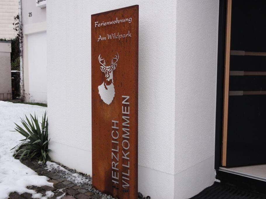 un cartello sul lato di un edificio con un cervo sopra di Ferienwohnung am Wildpark HDH a Heidenheim an der Brenz