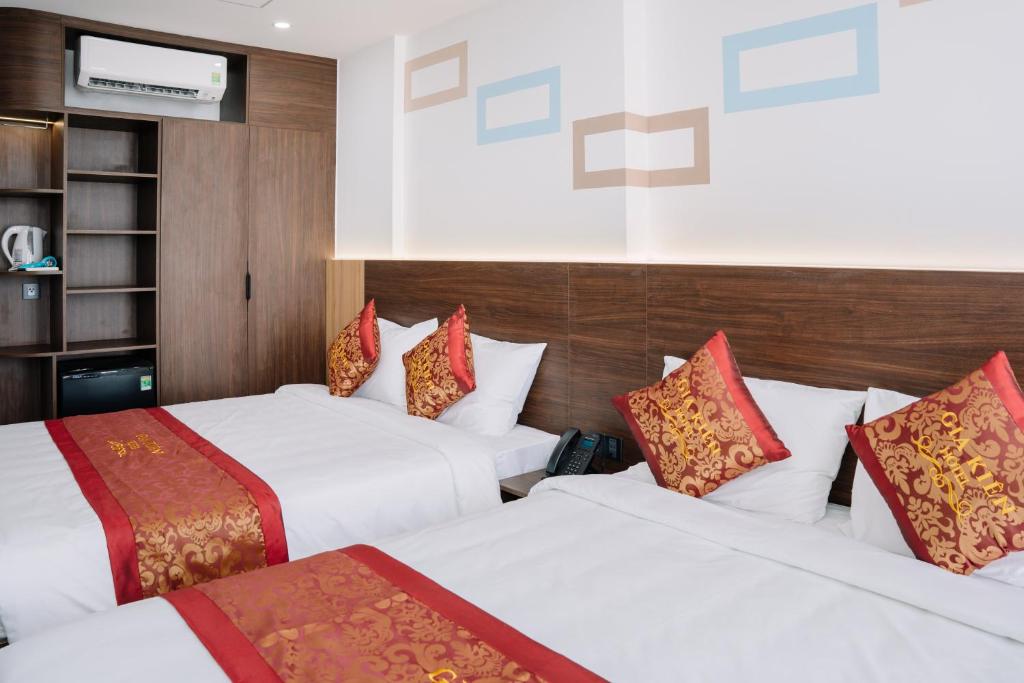 a hotel room with two beds and a television at Gia Kiên Hotel in Quy Nhon