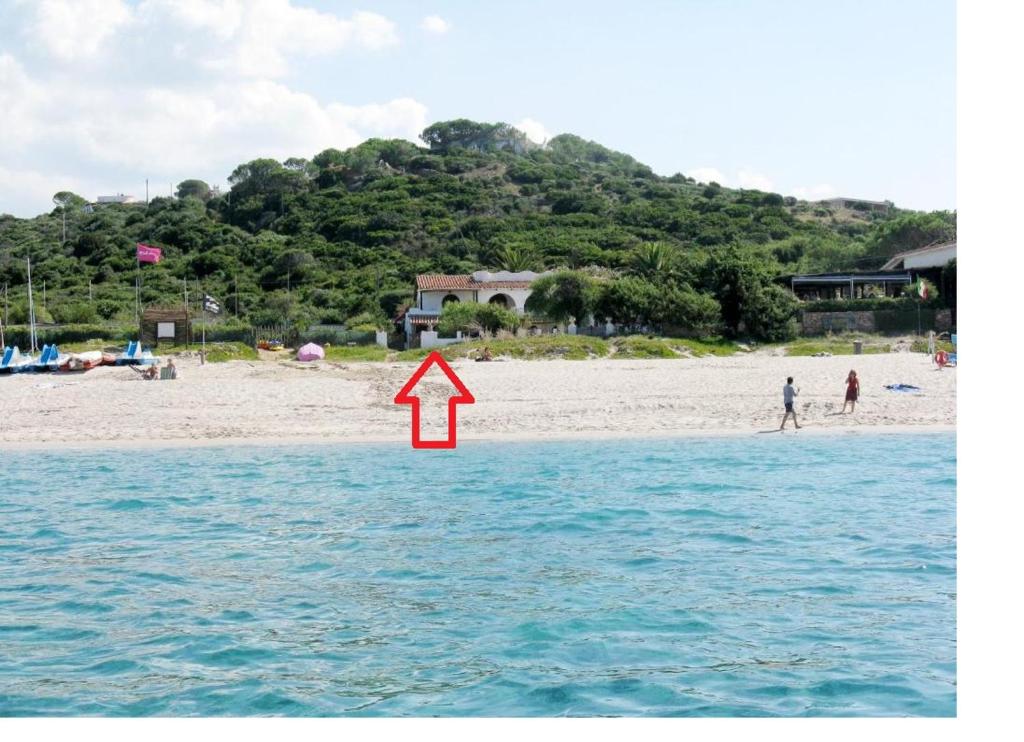 a red arrow is pointing to a beach at Studio Marinedda in Isola Rossa