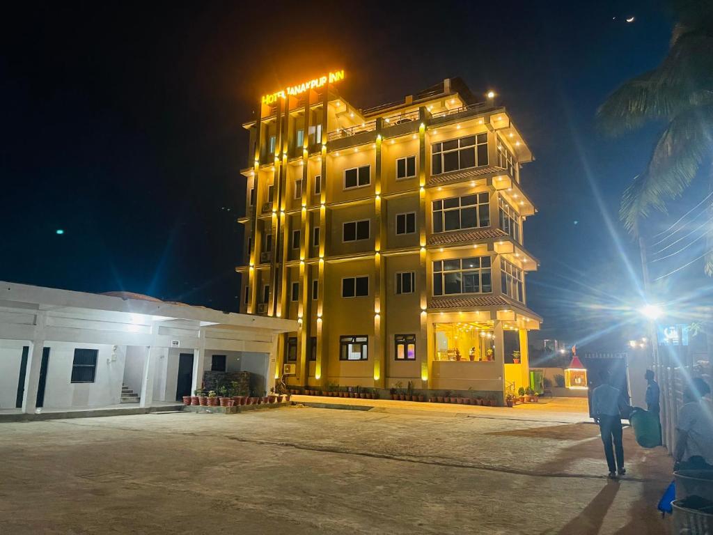 a tall yellow building with lights on it at night at Hotel Janakpur Inn in Janakpur