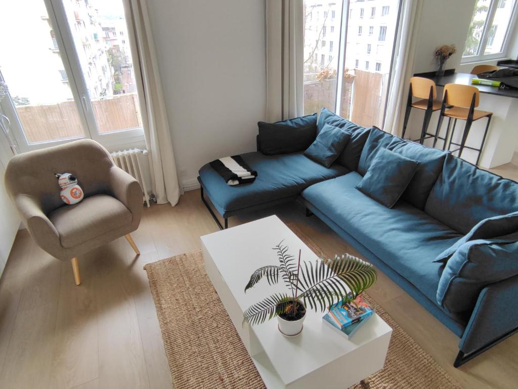 sala de estar con sofá azul y silla en Maria’s place, en Rueil-Malmaison