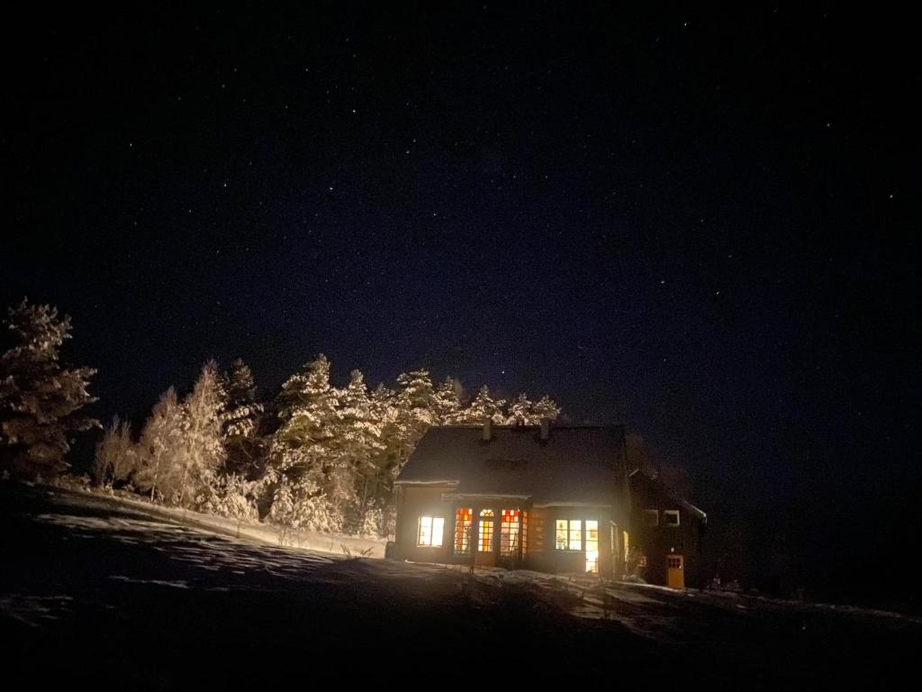 une maison éclairée la nuit dans la neige dans l'établissement Krasnogruda 7c, à Sejny