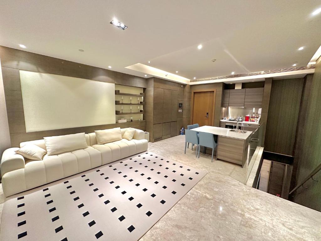 ZHome-Deplex luxury apartment-Near The Bund في شانغهاي: غرفة معيشة مع أريكة بيضاء ومطبخ