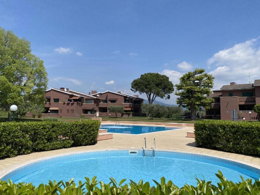 a large swimming pool in a yard with houses at Boutiqueapartment Lago in Bardolino
