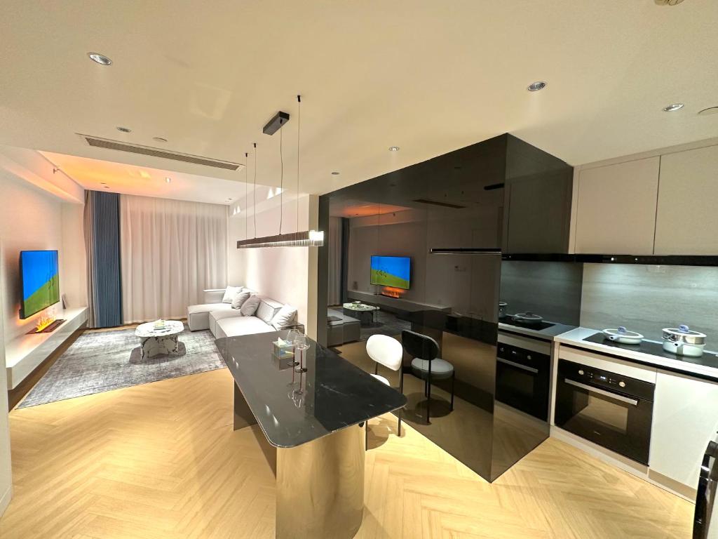 a kitchen with black appliances and a living room at ZHome-Count luxury apartment in Shanghai