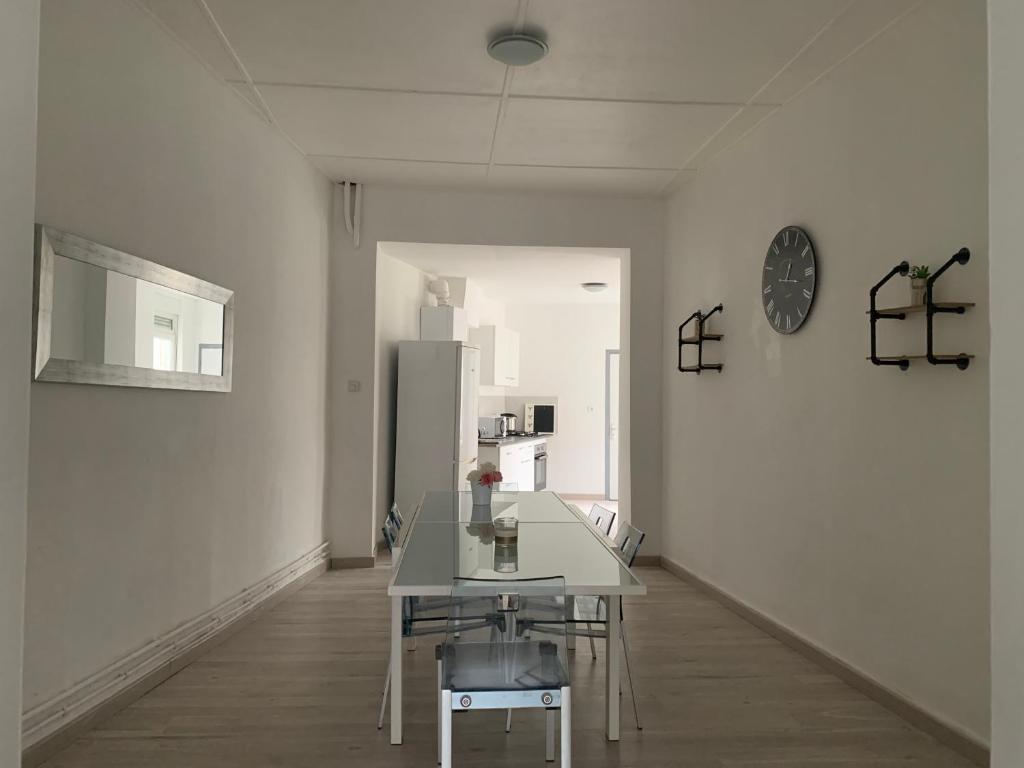 Camera bianca con tavolo e frigorifero. di Logement entier 100 m2 a Sin-le-Noble