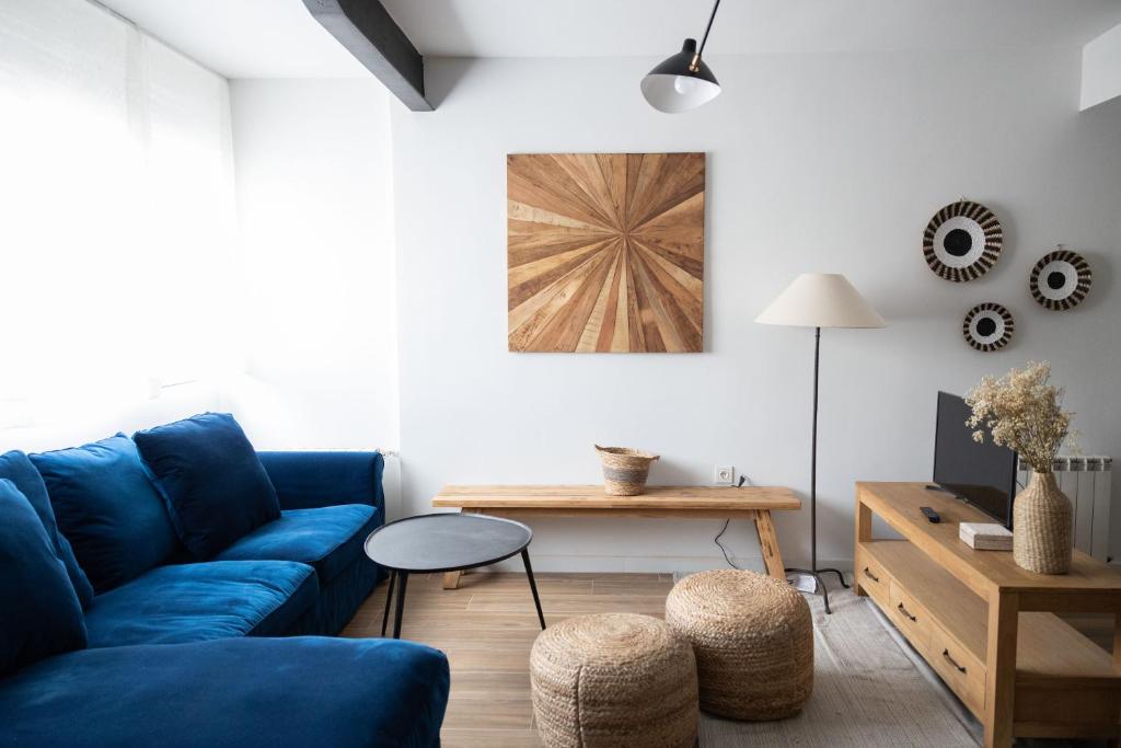 a living room with a blue couch and a table at Exclusive cozy Atocha apartment in Madrid