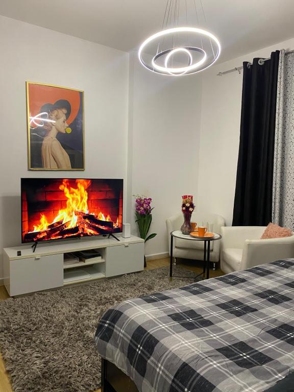 een woonkamer met een open haard en een televisie bij DALA MASTER Bedroom En-suite in Sharjah