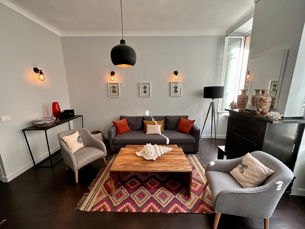 un salon avec un canapé, une table et des chaises dans l'établissement Stunning apartment in the Gold Square of Nice!, à Nice