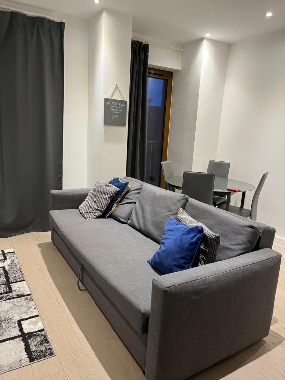 a grey couch with pillows on it in a living room at Maplewood properties - One bedroom luxurious apartment - Elm in St. Albans