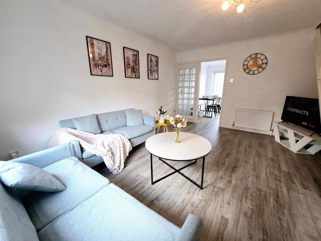 a living room with a blue couch and a table at Walderslade Serviced Accommodation Medway Maidstone in Kent