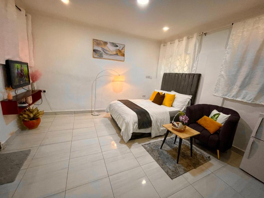 1 dormitorio con 1 cama y 1 sofá en Cozy Studio Apartment, en Dar es Salaam
