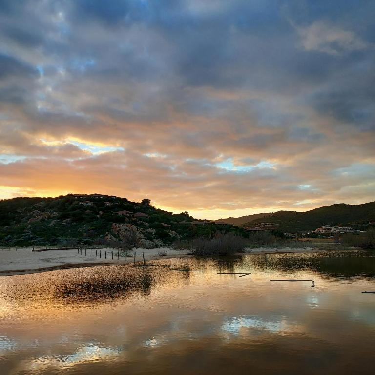 a body of water with a sunset in the background at La Rosa dei Venti B&B in Chia