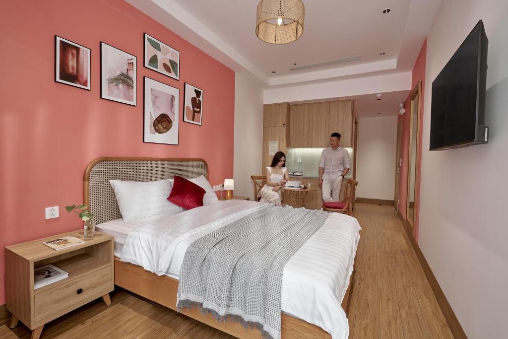 a bedroom with a large bed and a man in a room at Oceanhomes in Bien Ho
