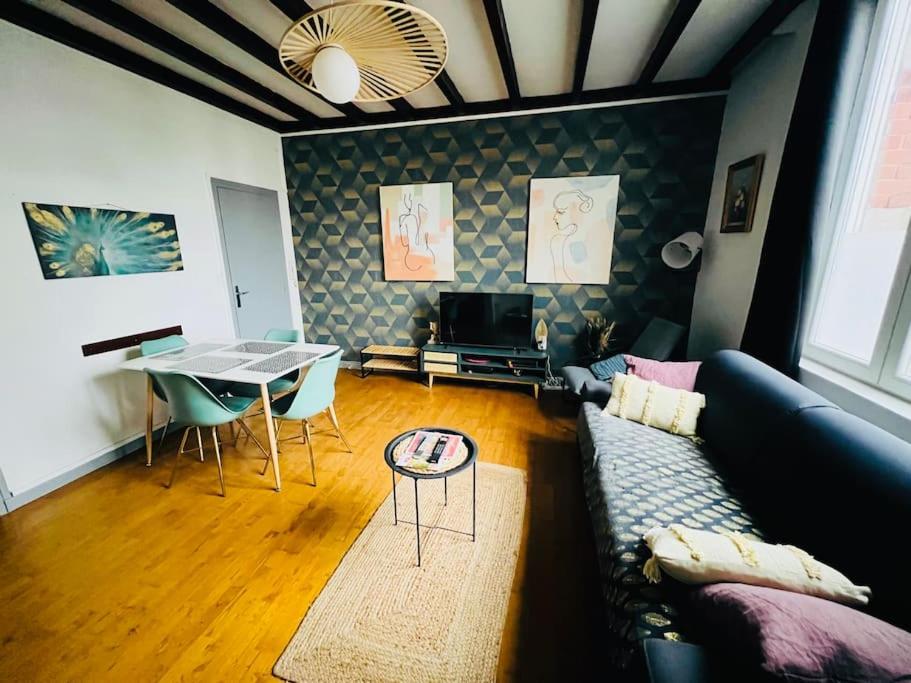un salon avec un canapé et une table dans l'établissement Apt Des Artistes, 3 min À Pied Gare et Centre, à Valenciennes