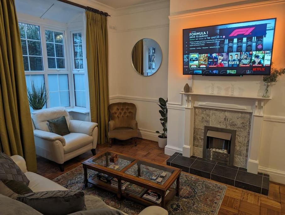 a living room with a fireplace and a flat screen tv at River's Edge in Stratford-upon-Avon