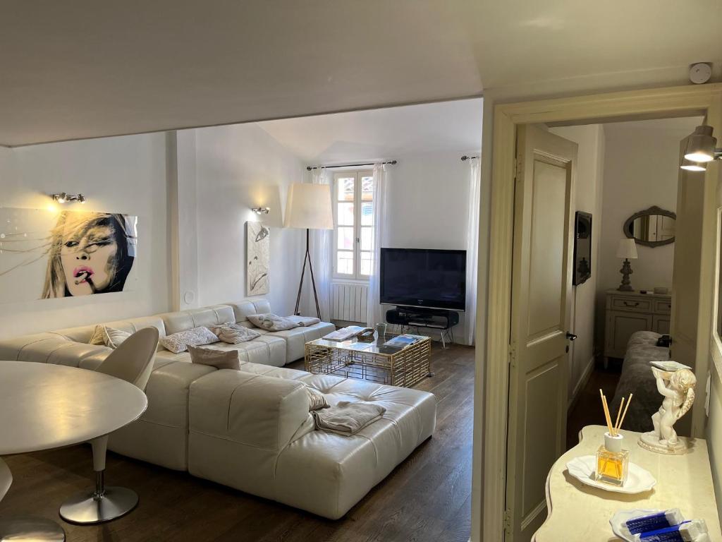 un salon avec un canapé blanc et une télévision dans l'établissement Appartement trois pièces Saint Tropez, à Saint-Tropez