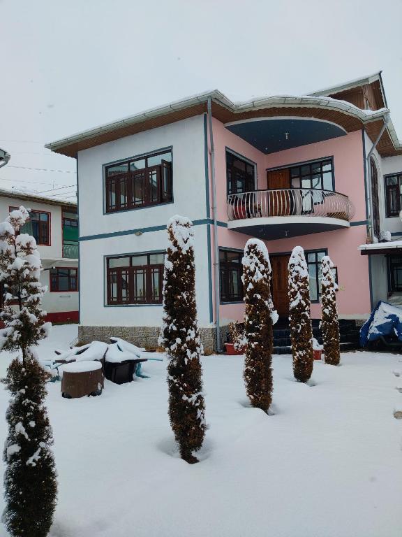 a house with snow covered trees in front of it at Kashmir Homestay in Takia Batpur