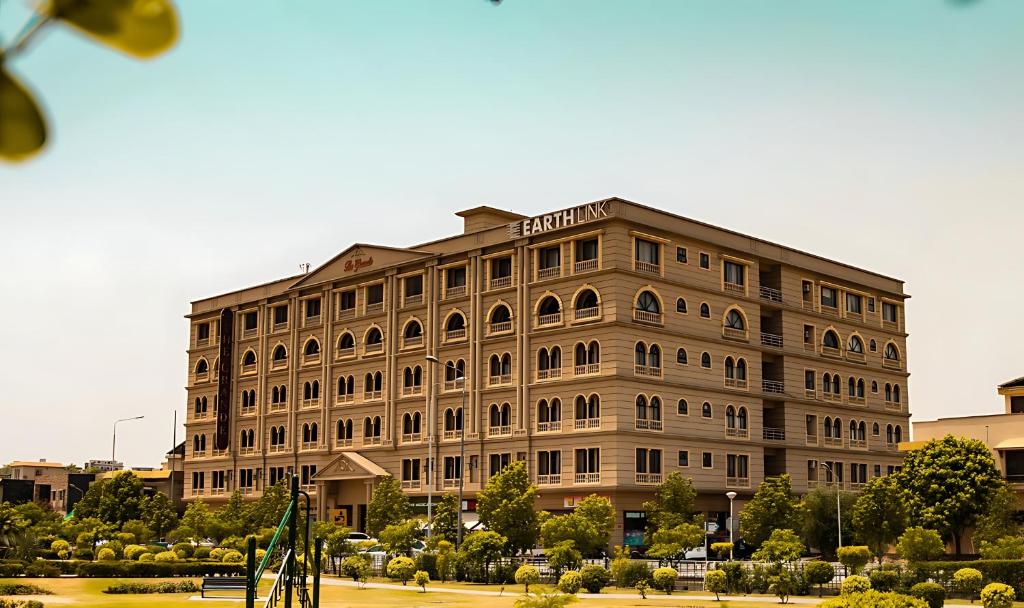 un grand bâtiment avec une enseigne au sommet dans l'établissement Deluxe Luxury Apartment, à Rawalpindi