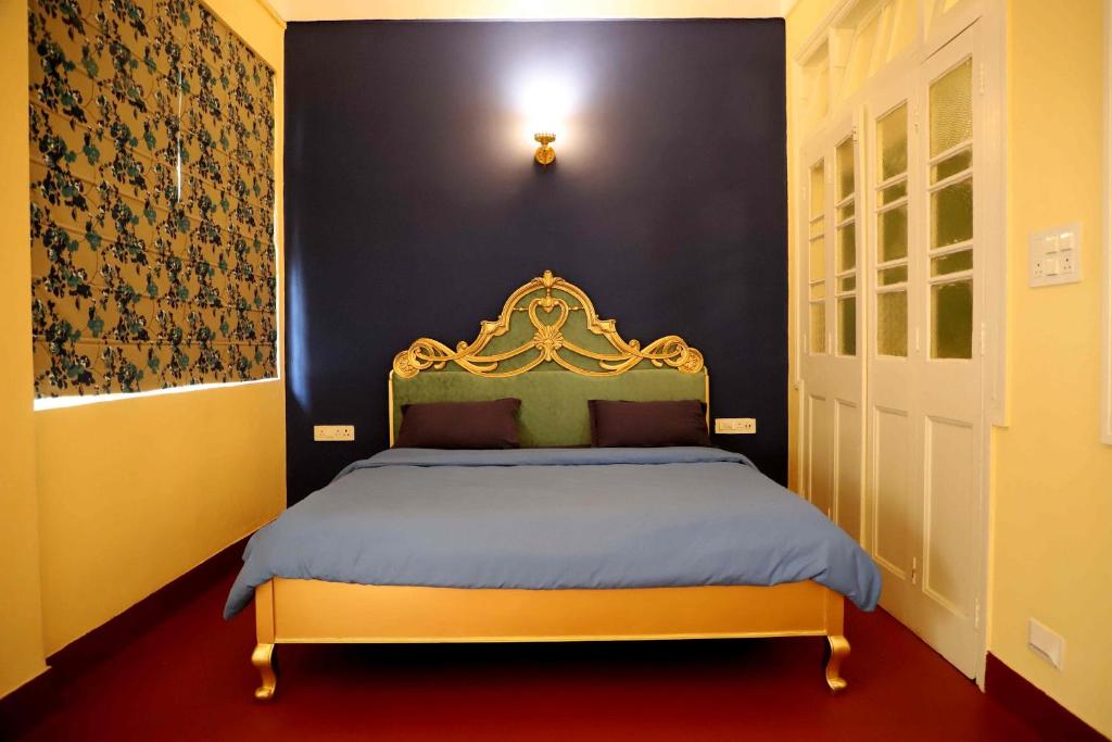 a bedroom with a king sized bed with a black wall at Heritage Home in Central Kolkata in Kolkata