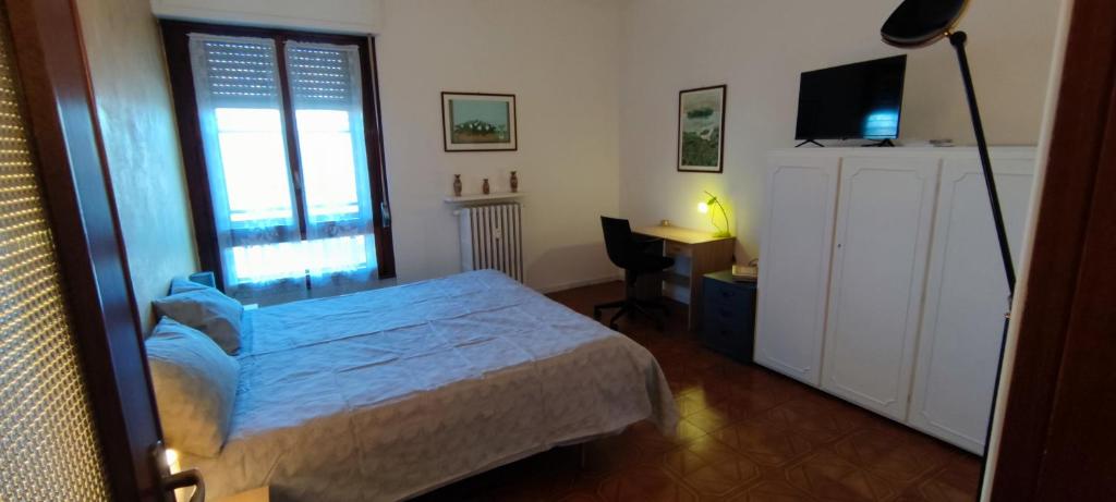 a bedroom with a bed and a desk and a television at Casa Robert in Alessandria